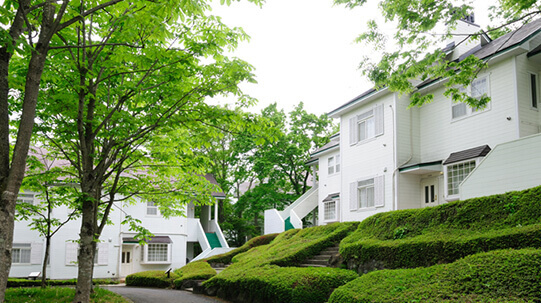 高原リゾート「那須高原TOWAピュアコテージ」白くて清潔感のある建物。緑あふれるコテージ。